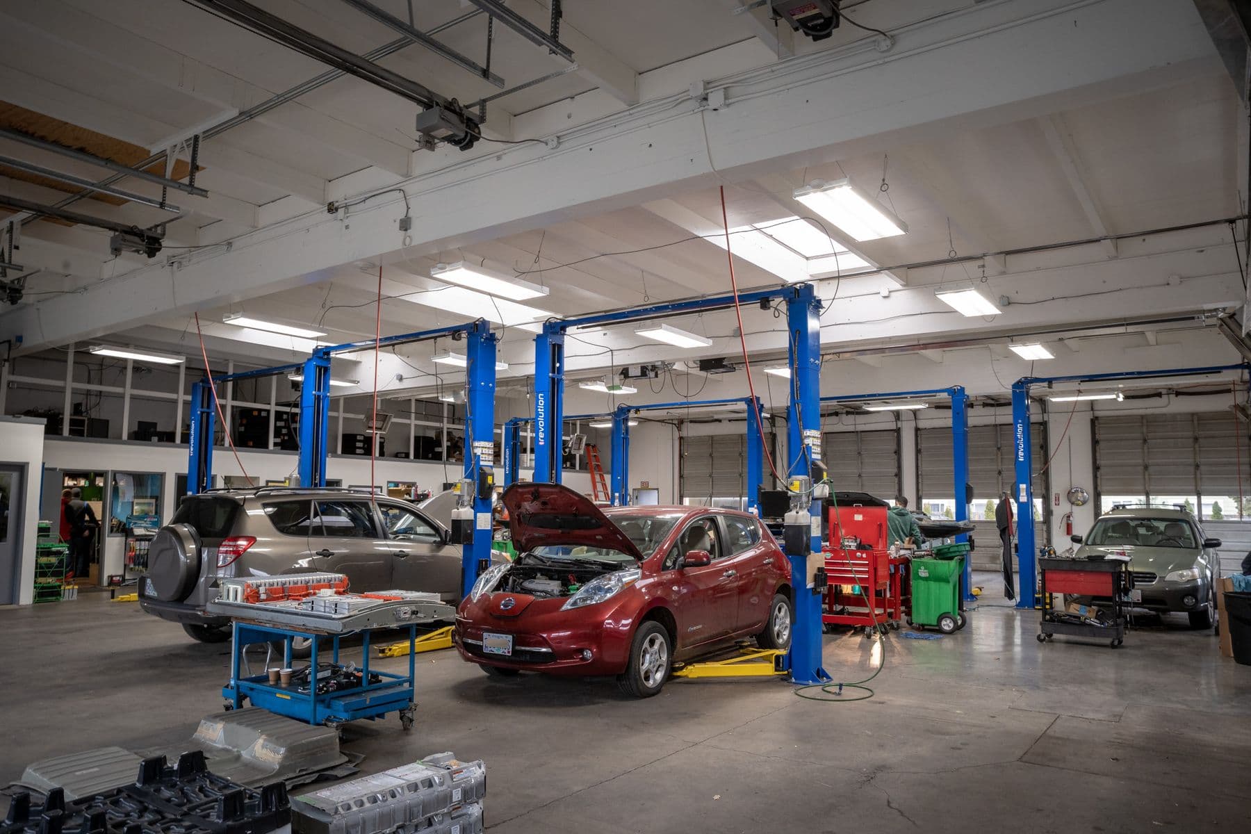 A Nissan Leaf and a RAV4 on the shop floor at Atomic Auto