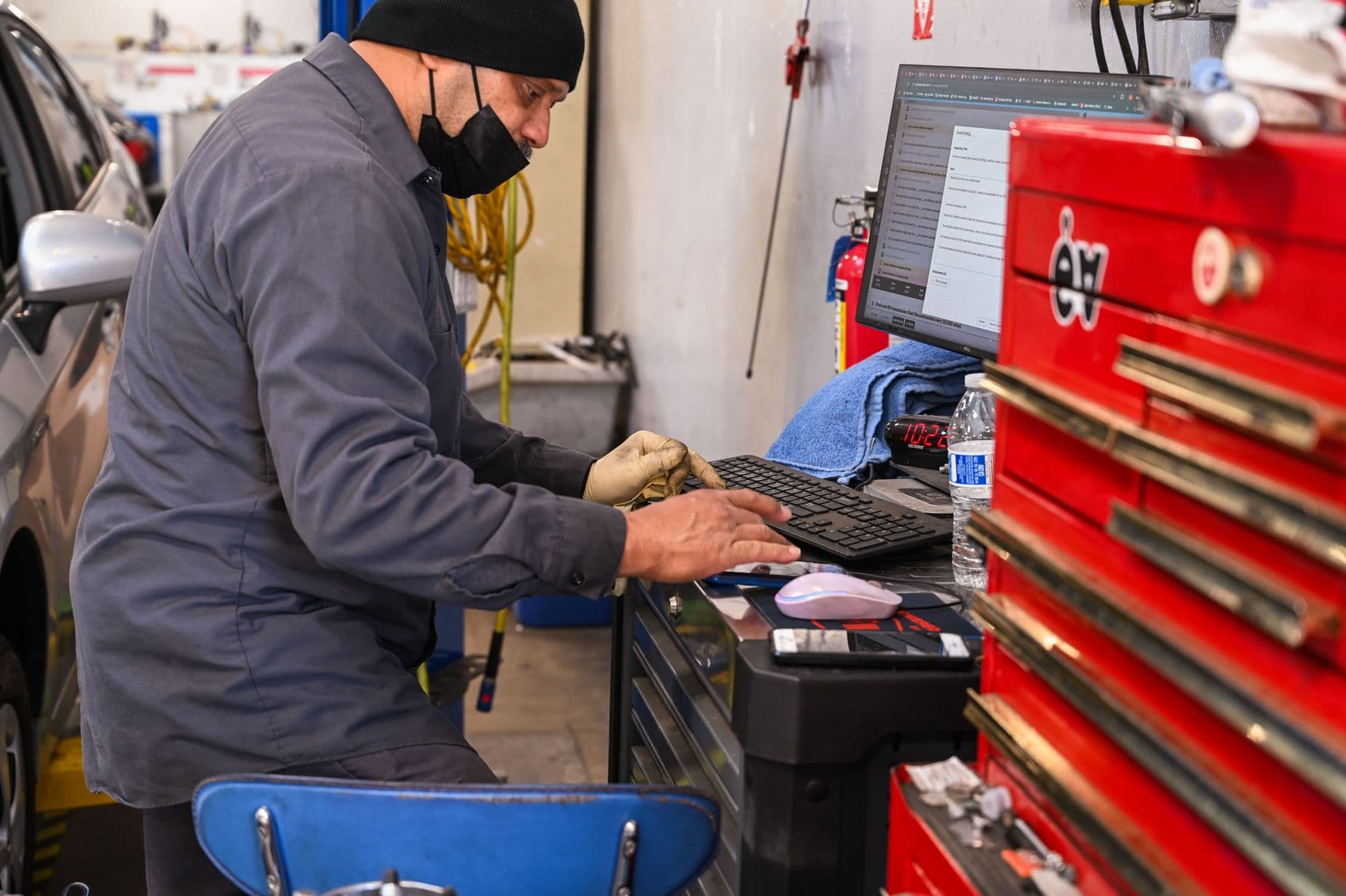 A technician at the bay computer beside his toolbox at Earthling Automotive