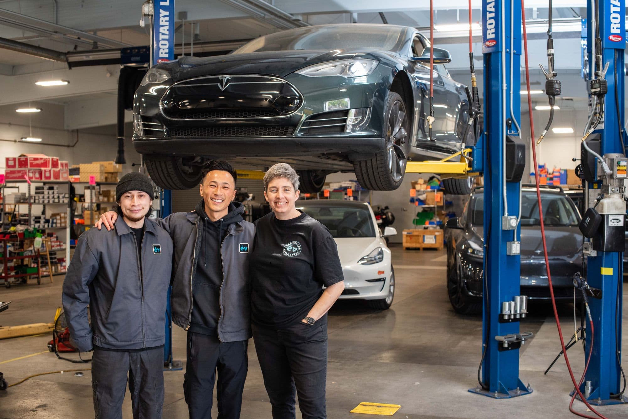 Three technicians at a car on the lift at Earthling Automotive