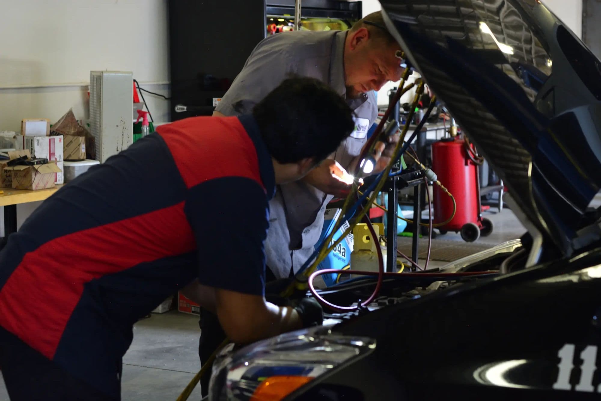 Two Mile Hybrid technicians working under a hood