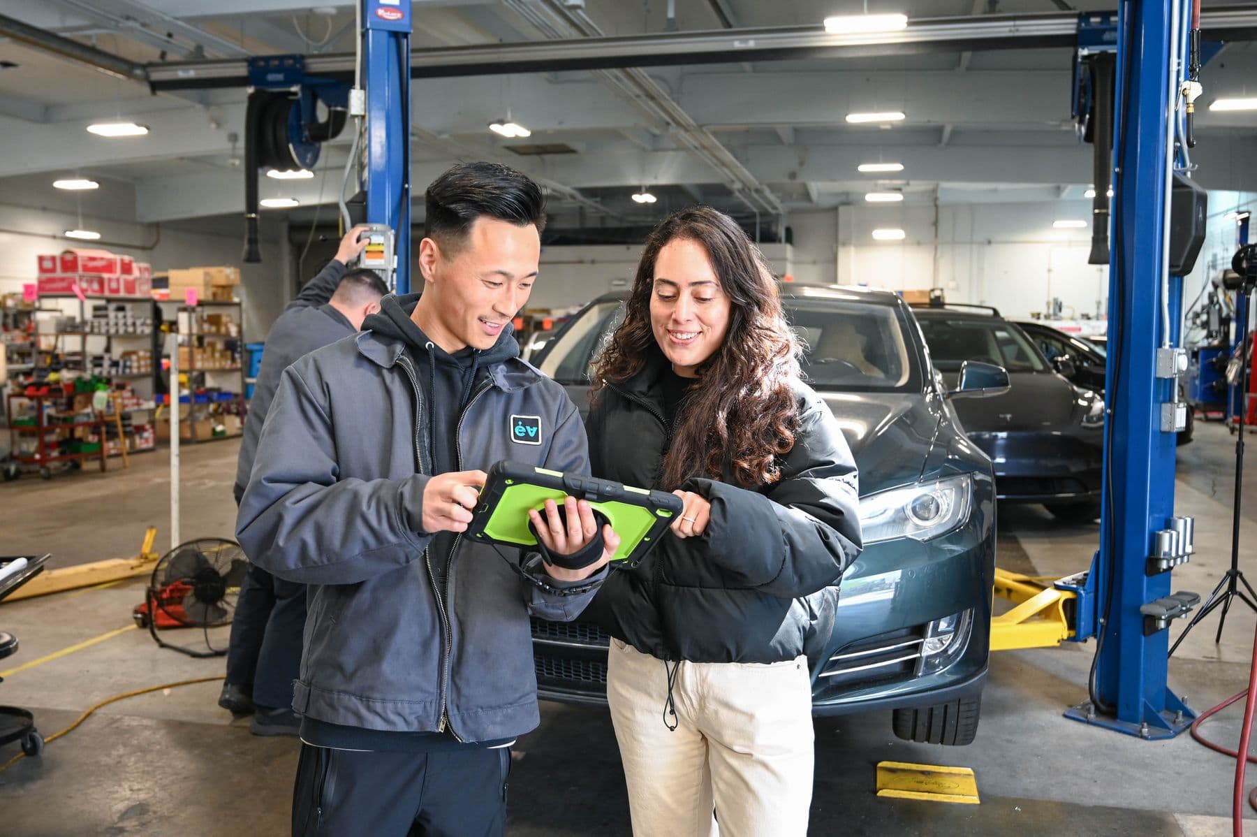 Going over an inspection on a tablet in the bay at Earthling Automotive