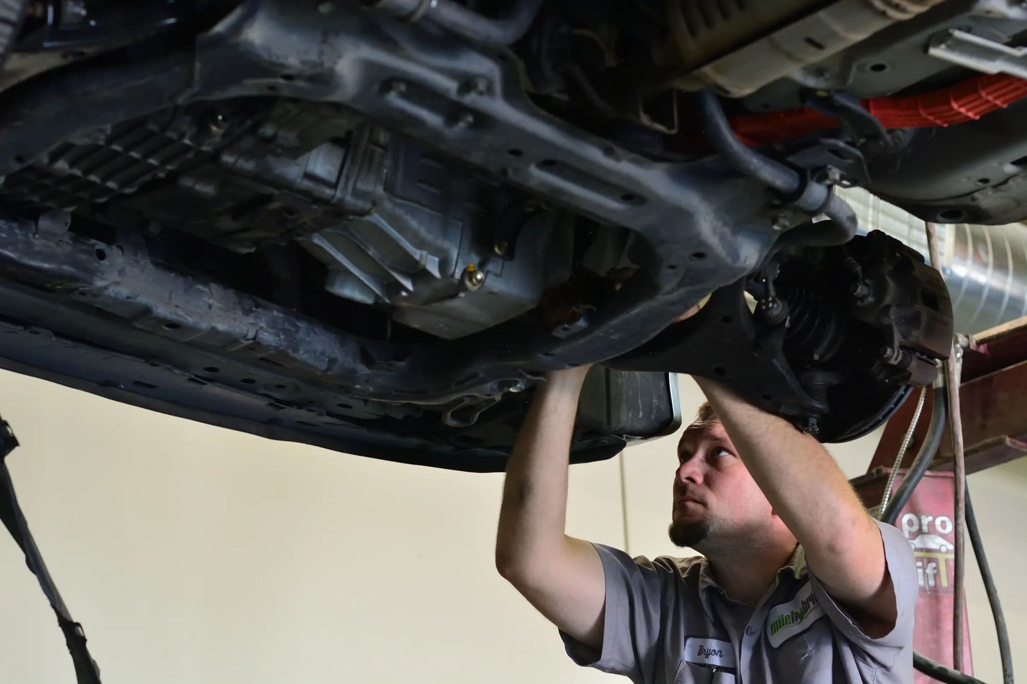 A technician under a hybrid on the lift at Mile Hybrid